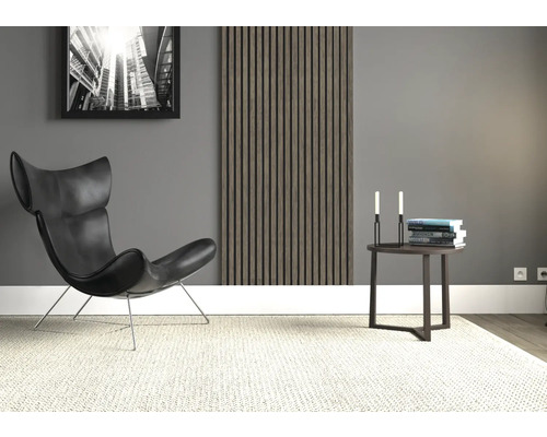 Living cu fotoliu, măsuță laterală, panou de perete și o imagine încadrată.