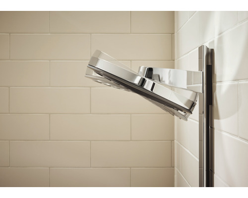 Cap de duș cromat montat pe un perete cu gresie