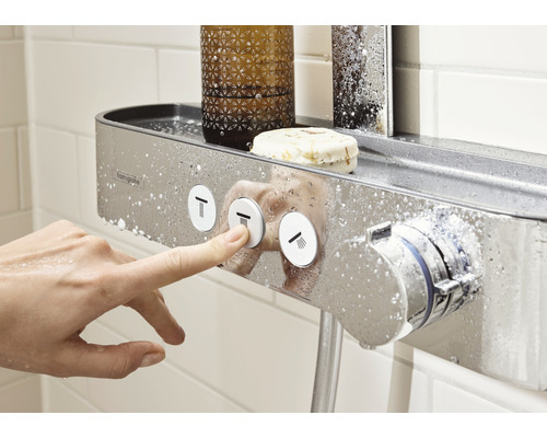 Baterie de duș cu spațiu de depozitare în baie, o mână operează butoanele