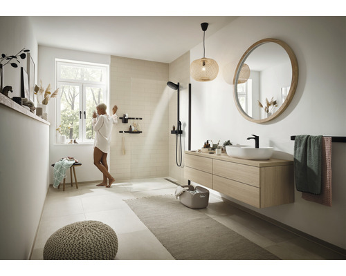 Baie luminoasă cu duș, lavoar, oglindă și decorațiuni pentru o ambianță modernă.