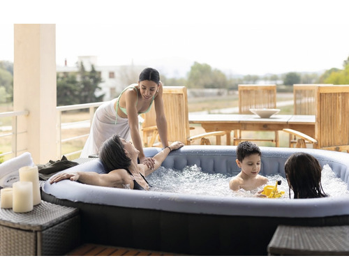Familie se relaxează într-un jacuzzi gonflabil pe o terasă.
