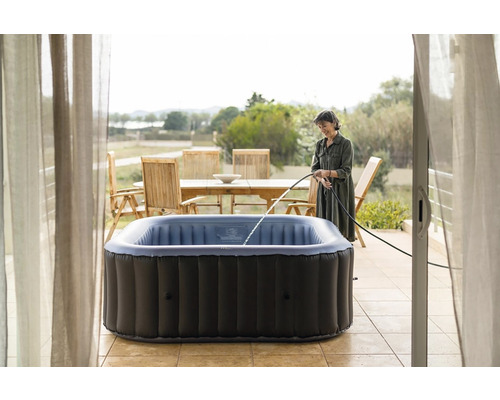 Cada cu hidromasaj gonflabilă umplută cu un furtun de apă pe o terasă