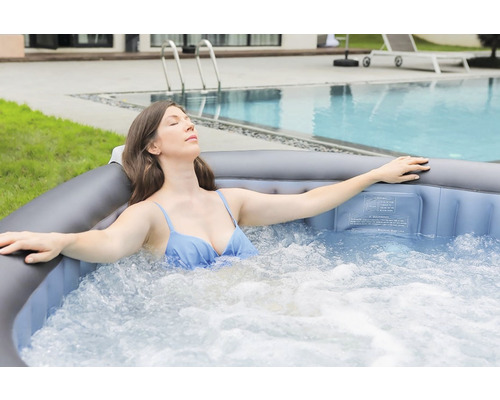 Femeie relaxându-se într-un jacuzzi gonflabil în aer liber