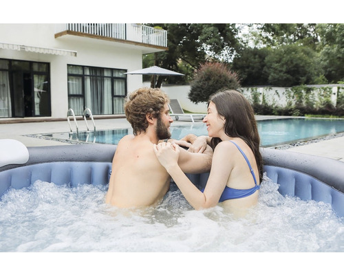 Un cuplu se relaxează într-un jacuzzi gonflabil în grădină