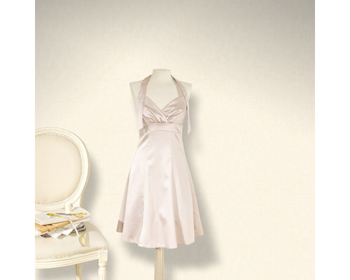 Rochie cu bretele după gât pe un manechin lângă un scaun