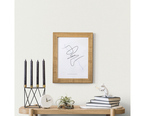 Scenă decorativă cu lumânări, ramă foto și accesorii pe o masă.