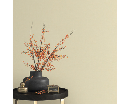 Aranjament decorativ cu vază, ramuri și cutie de bijuterii pe o masă.