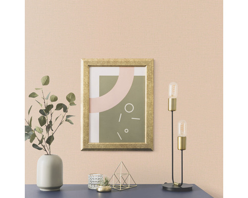 Cameră de zi cu o fotografie într-un cadru auriu, o lampă și o vază cu plante pe o comodă.