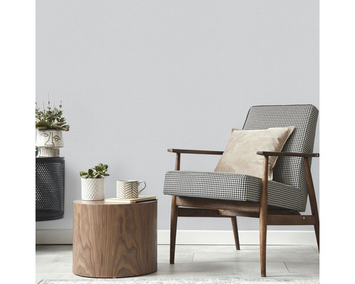 Cameră luminoasă cu fotoliu, măsuță laterală și plante de interior