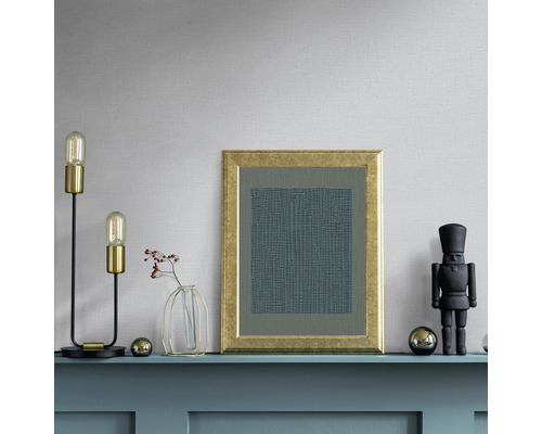 Aranjament decorativ pe un raft cu lampă, tablou, vază și spărgător de nuci