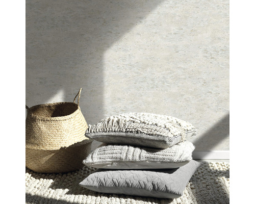 Natură statică decorativă cu perne, covor și coș în fața unui perete