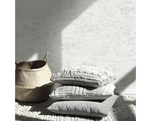 Scenă decorativă cu stivă de perne, coș și covor pentru design interior.