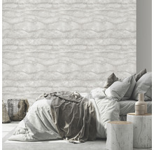 Dormitor cu pat în fața unui tapet deschis la culoare cu model de valuri