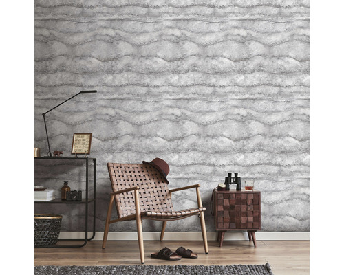 Cameră de zi cu tapet cu model, fotoliu și măsuță laterală.