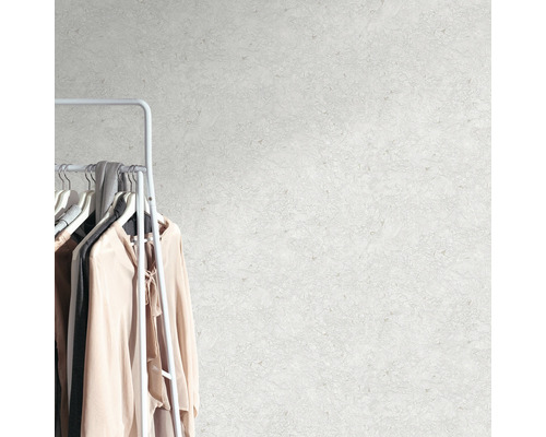 Perete cu model abstract lângă un suport de haine cu articole de îmbrăcăminte.