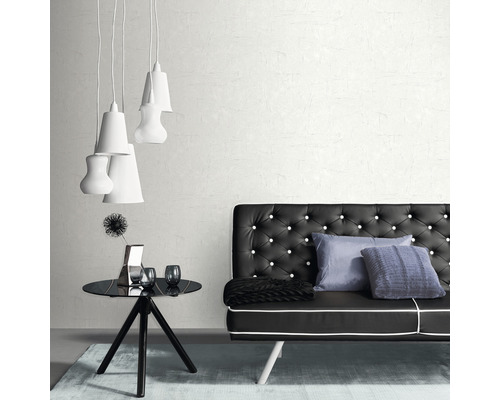 Interiorul unei camere cu o canapea neagră cu nasturi, o masă neagră, decorațiuni și mai multe lămpi albe