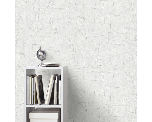 Scenă cu un tapet alb cu model de zgârieturi și un raft alb cu decorațiuni