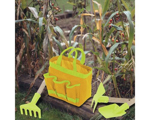 Scenă de grădină cu geantă pentru unelte de grădinărit, greblă, sapă și lopată.