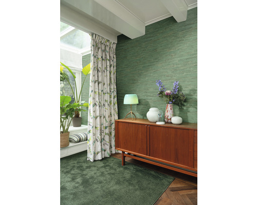 Living cu tapet textil verde, covor, perdele și comodă din lemn