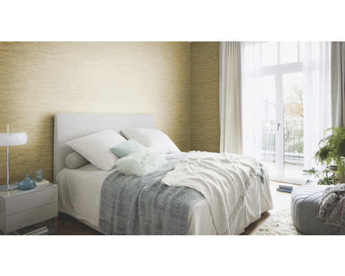 Dormitor cu pat, noptieră și tapet auriu pe perete.