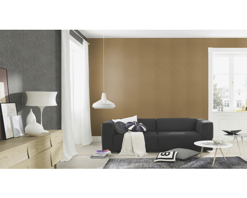 Cameră de zi cu canapea, măsuță laterală, comodă și veioză suspendată în fața unui tapet cu model