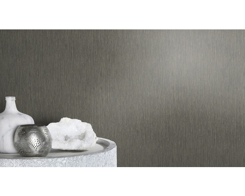 Prim-plan cu tapet de perete texturat lângă obiecte decorative pe o masă.