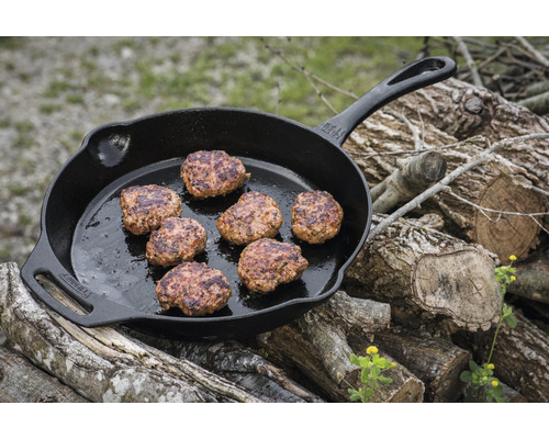 Tigaie din fontă cu chiftele pe un stivuitor de lemn