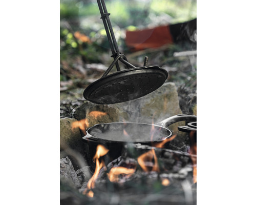 Gătit la foc deschis cu o oală și capac.