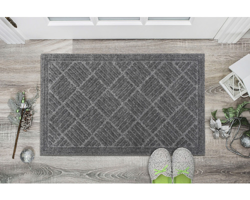 Covoraș de intrare gri cu model geometric în fața unei uși