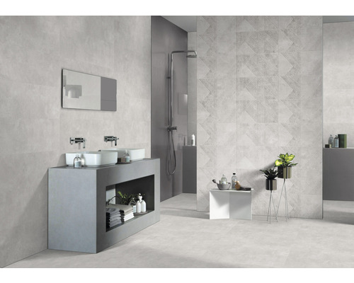 Baie modernă cu chiuvetă, oglindă, duș și gresie cu model geometric.