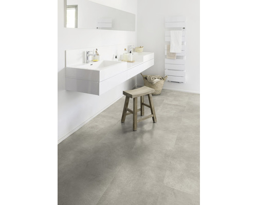 Baie luminoasă cu chiuvetă dublă, oglindă, calorifer pentru prosoape, taburet și gresie cu aspect de piatră.