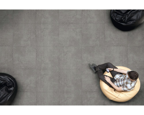 Gresie de podea gri cu un bărbat pe un puf și două pufuri negre