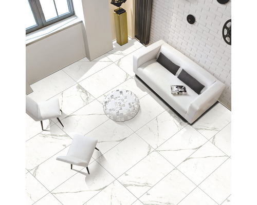 Cameră luminoasă cu gresie de marmură albă, canapea și fotolii