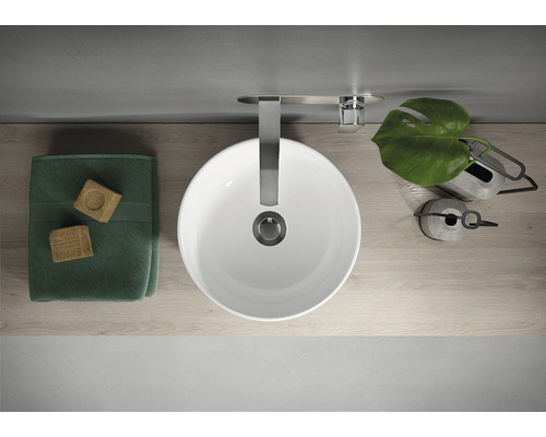 Vedere de sus a unei chiuvete cu robinet, prosop și decorațiuni pe un raft