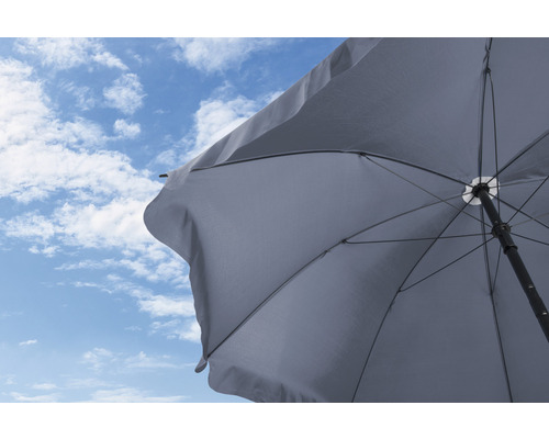 Umbrelă de soare deschisă pe un cer albastru cu nori