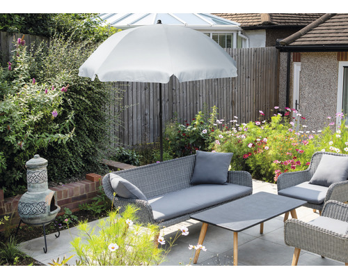 Set de mobilier de grădină cu umbrelă de soare, canapea, fotolii și masă pe o terasă.