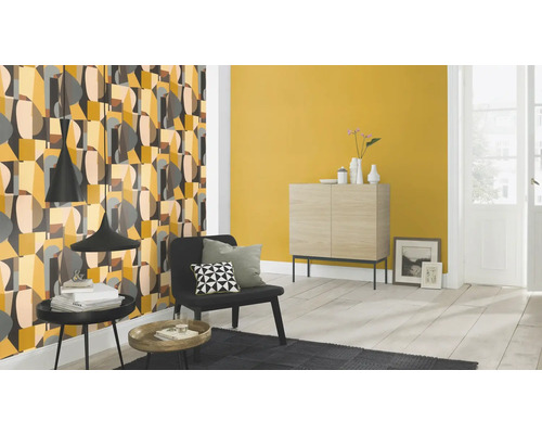 Living cu tapetă cu model, comodă și fotoliu.