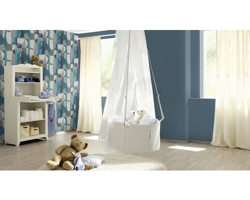 O cameră de copii cu masă de înfășat, coș suspendat cu baldachin și articole decorative.