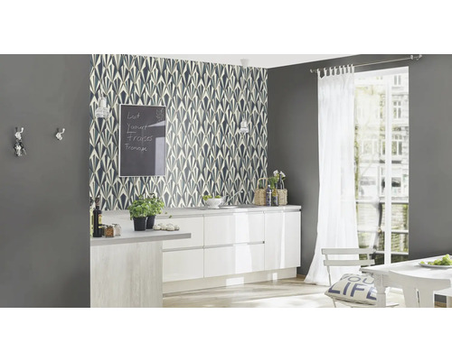 Scenă de bucătărie cu tapet cu model, mobilier de bucătărie și decorațiuni.