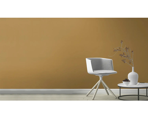 Scenă cu un scaun și o măsuță laterală în fața unui perete colorat