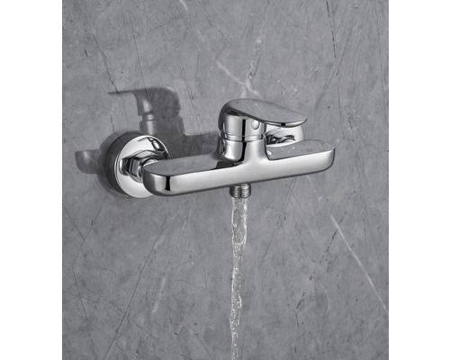 Baterie de duș cu jet de apă în fața unui perete gri