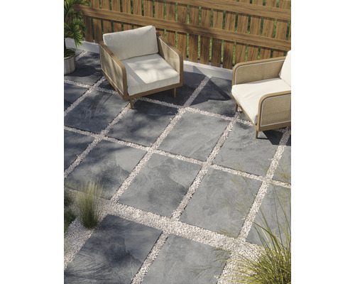 Terasa cu plăci de piatră și suprafețe de pietriș, precum și două fotolii