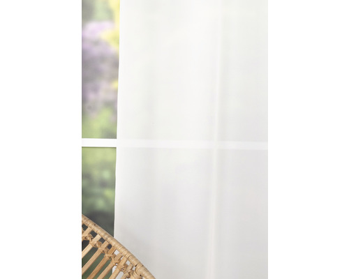 Fereastră cu perdea albă și fotoliu de răchită în cameră