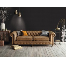 Cameră de zi cu canapea din piele maro în stil Chesterfield, podea din lemn și elemente decorative