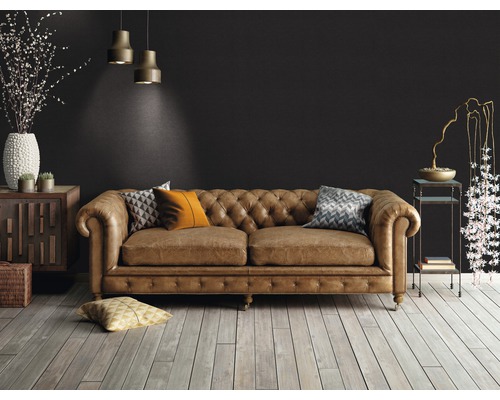 Cameră de zi cu canapea din piele maro în stil Chesterfield, podea din lemn și elemente decorative