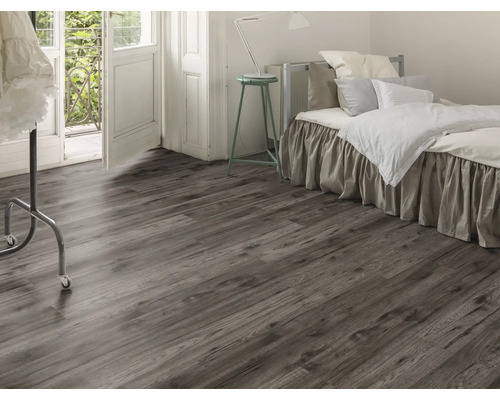 Dormitor cu podea laminată cu aspect de lemn, pat și ușă de balcon