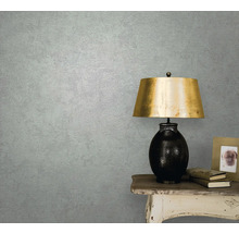 Prim-plan al unui perete de cameră cu tapet, o masă și o lampă