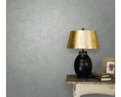 Prim-plan al unui perete de cameră cu tapet, o masă și o lampă