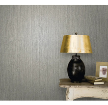 Prim-plan cu un tapet texturat într-o cameră cu o masă și o lampă