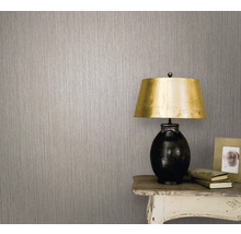 Prim-plan al unui perete cu tapet netesut și o lampă pe o masă